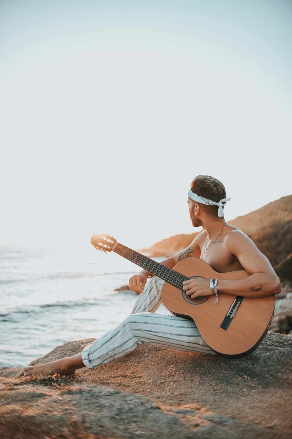 man sitting on rock near ocean