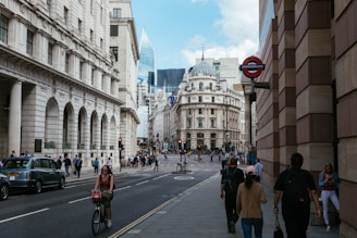 A vibrant street scene in London showing diverse communities engaging in local business and culture under a clear sky.