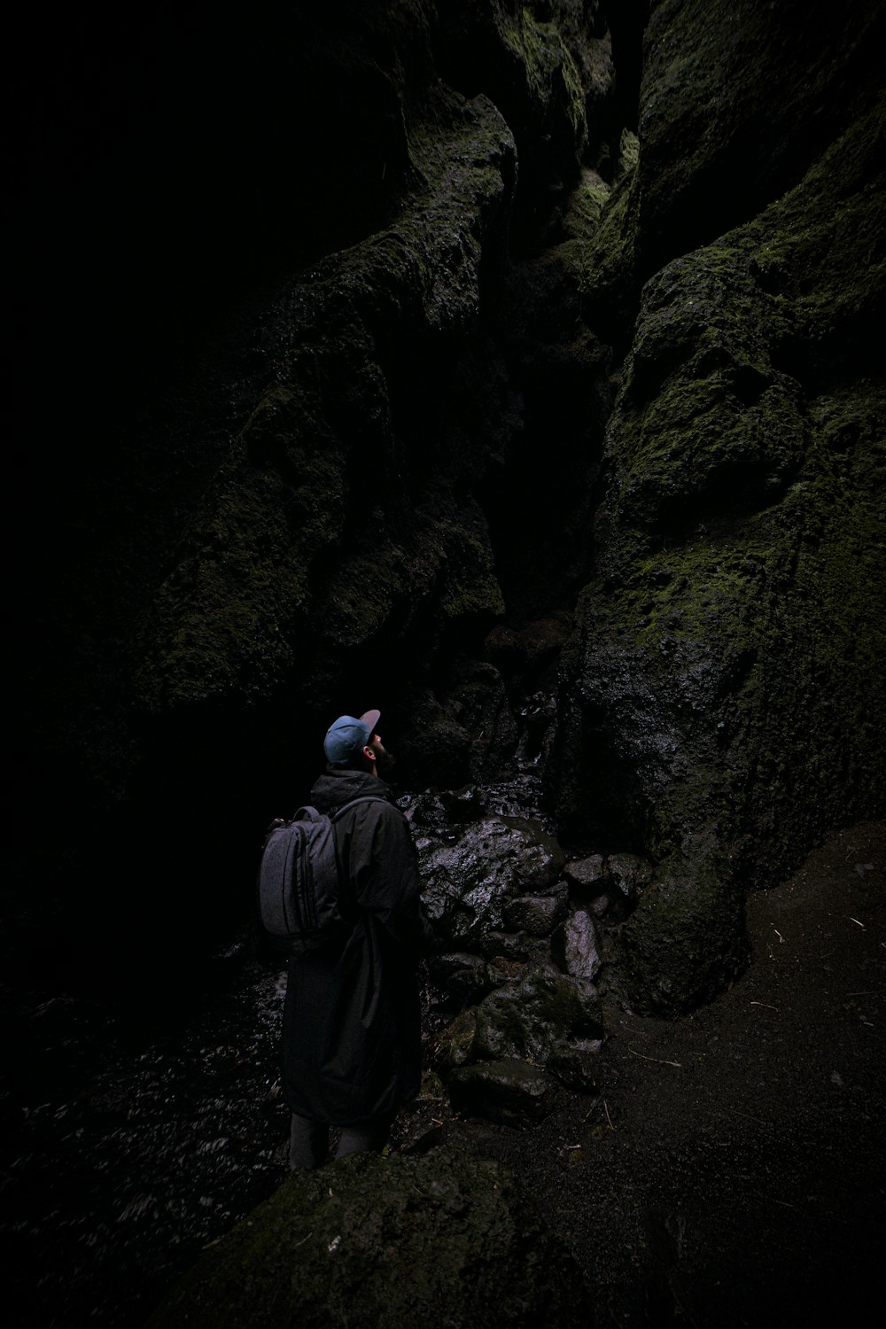 man with backpack standing and looking up