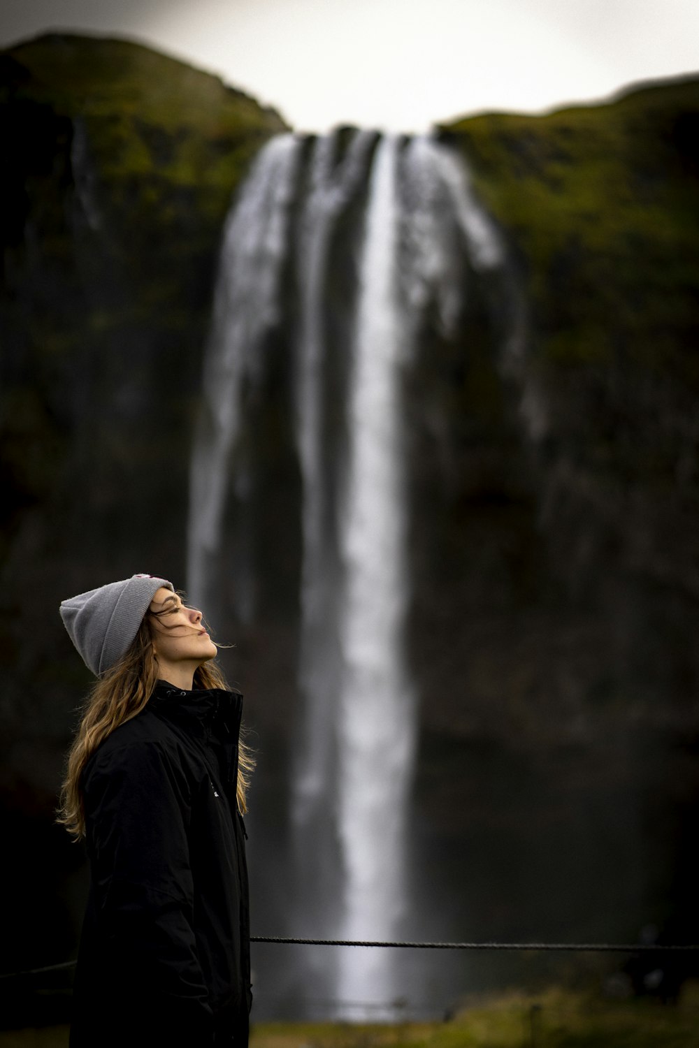 woman standing near waterfalls