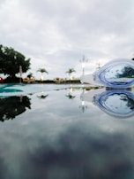Close-up of swimming goggles resting on the edge of a pool with water droplets.