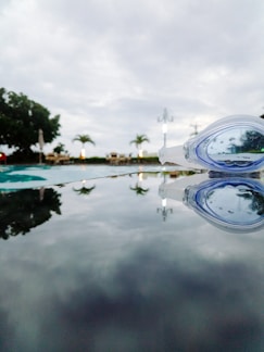 Close-up of a sleek, high-quality swim goggle resting on a pool edge.