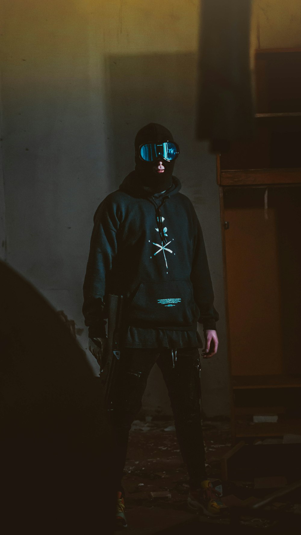 man wearing black jacket holding assault rifle