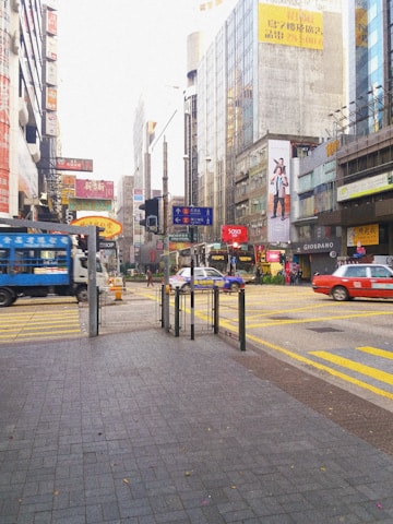 A vibrant city street with various vehicles showcasing colorful full and partial wrap advertisements.