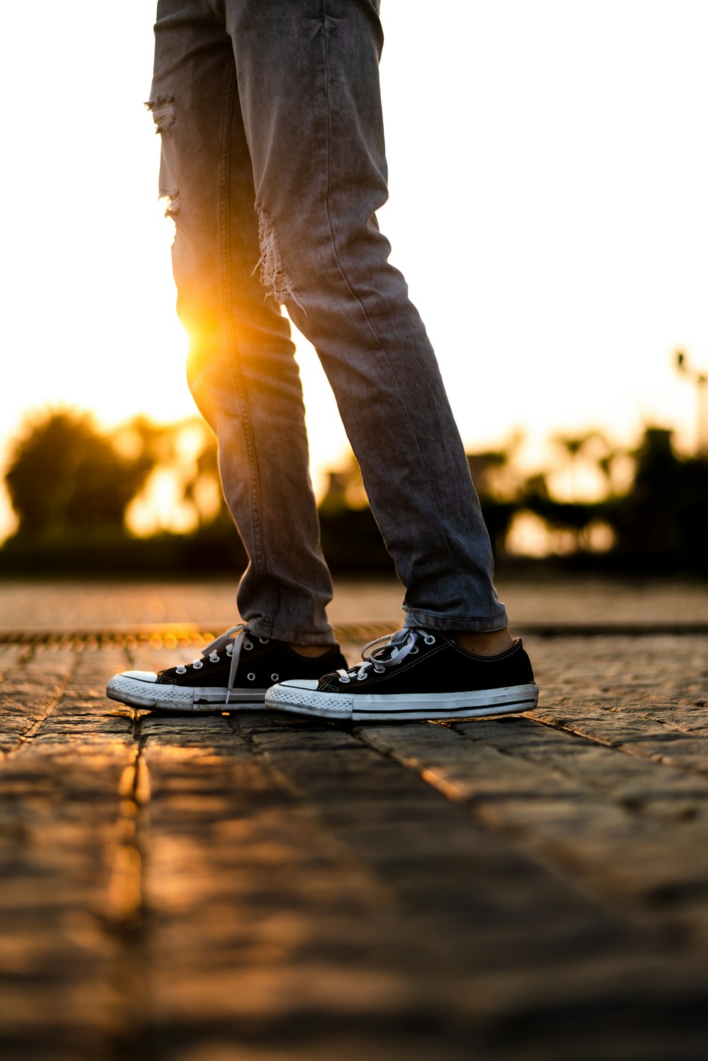 person wearing gray denim jeans and black low-top shoes