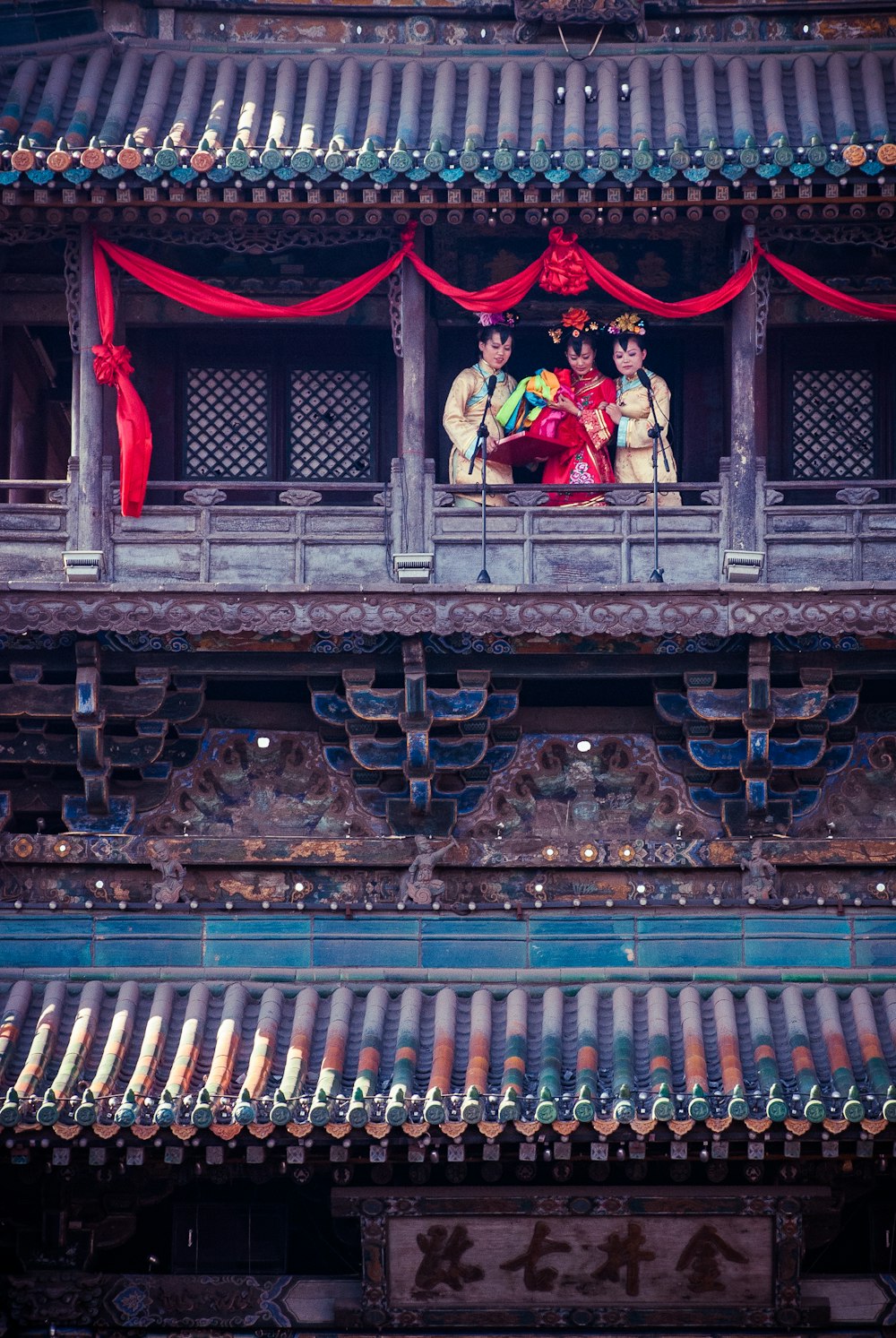 3 personnes debout sur le balcon de la maison