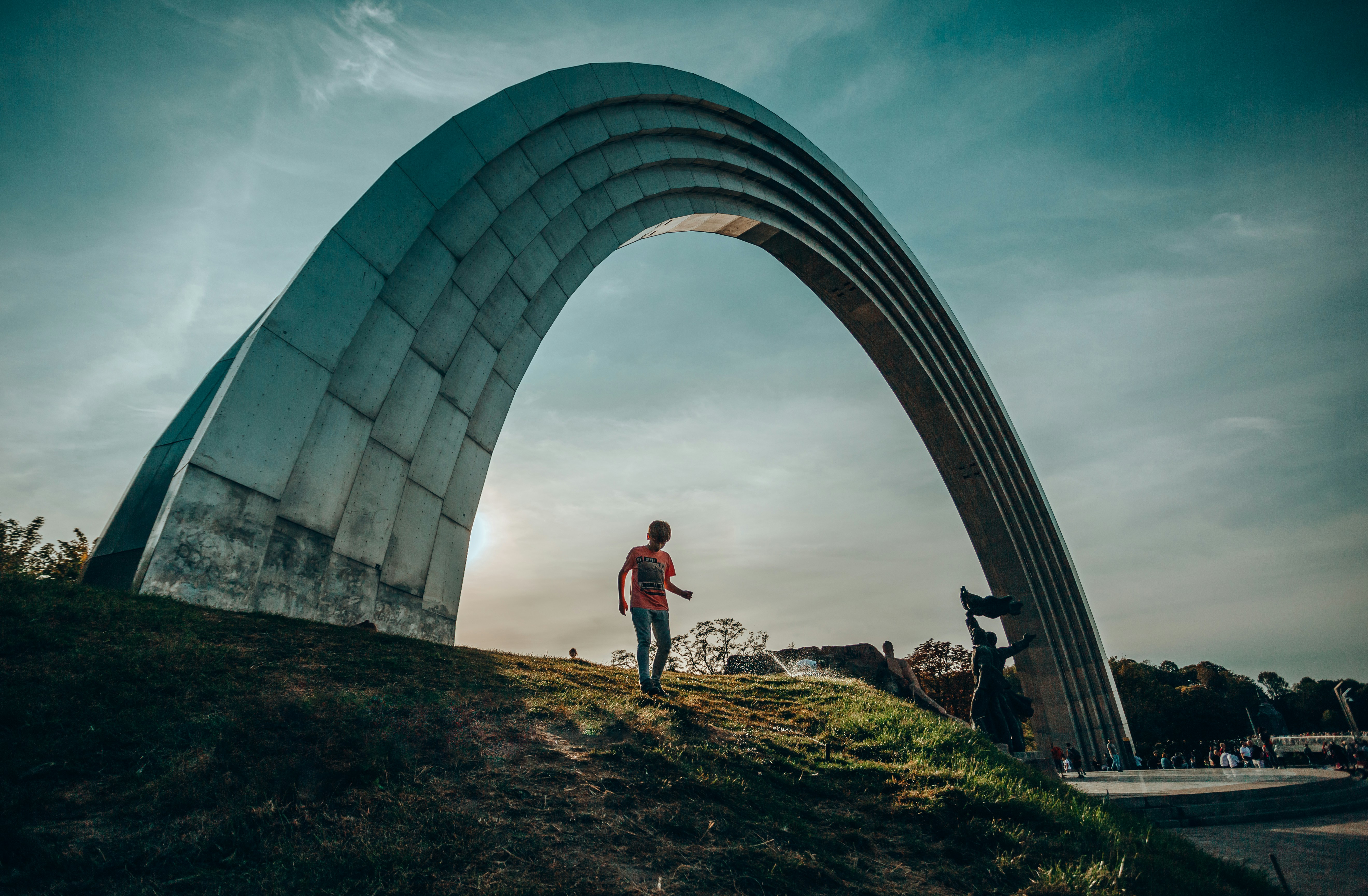 man standing beside arch building