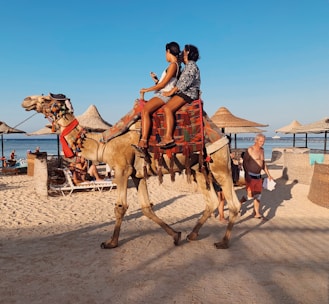 two women riding on camel's back