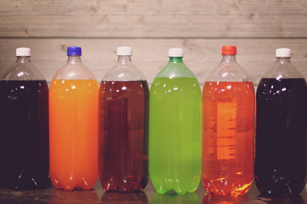 six plastic bottles with assorted-color liquid