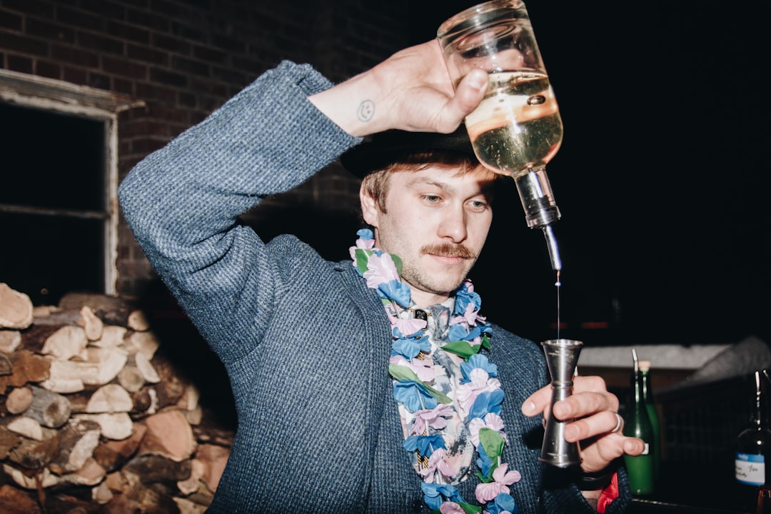 man pouring drink on gray cup