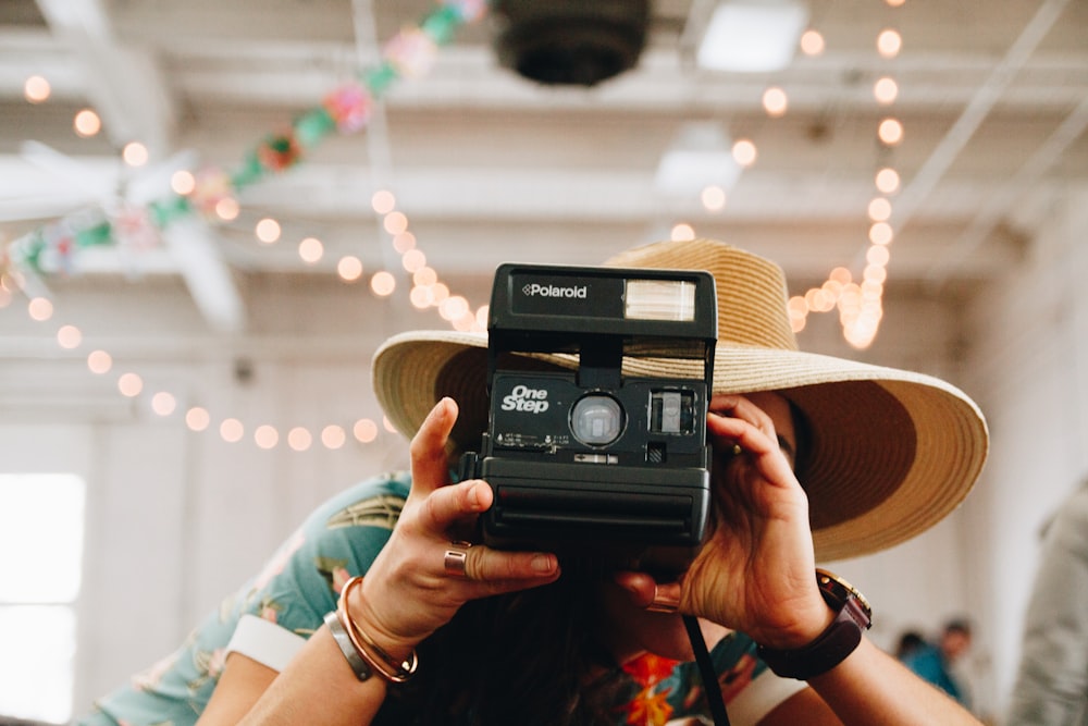 person using black Polaroid camera