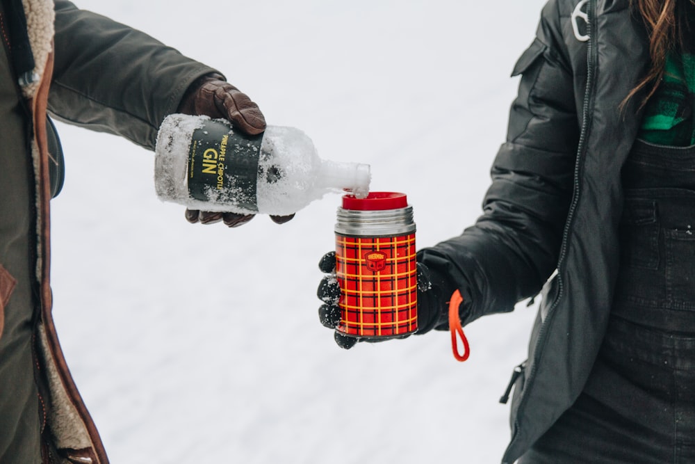 men pouring water on cup