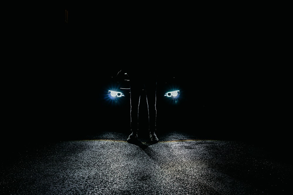 Eine Person, die mitten auf einer dunklen Straße steht