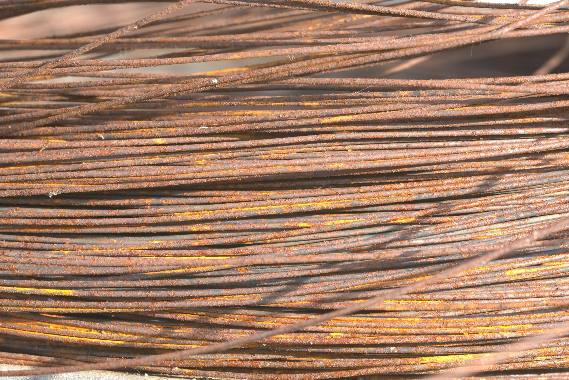 A close-up shot of shiny copper wires bundled together, reflecting light in a scrapyard setting.