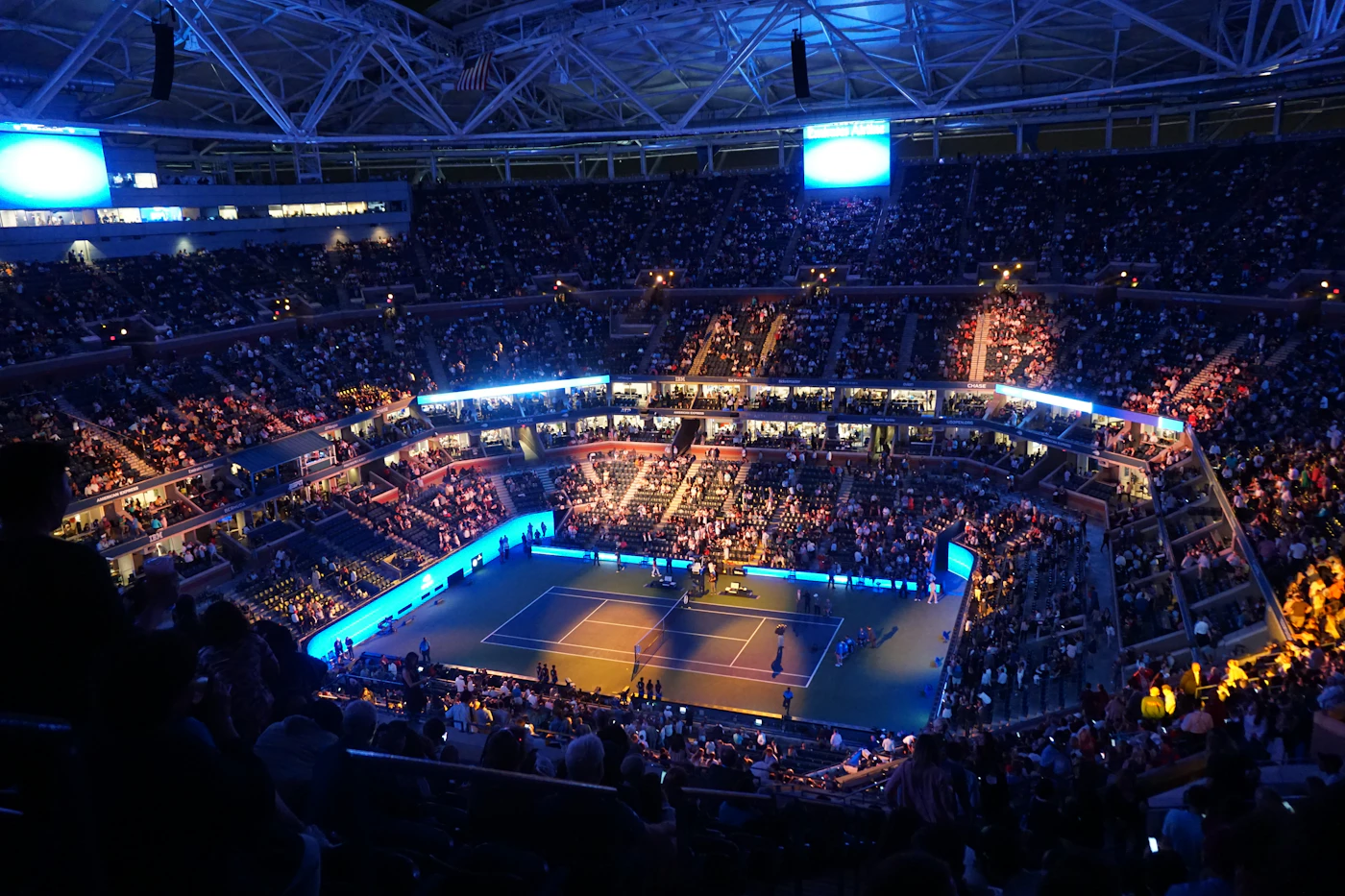 Illuminated tennis stadium at night during the US Open in New York