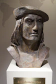 An old, cracked bust of a mysterious historical figure with a haunting expression.