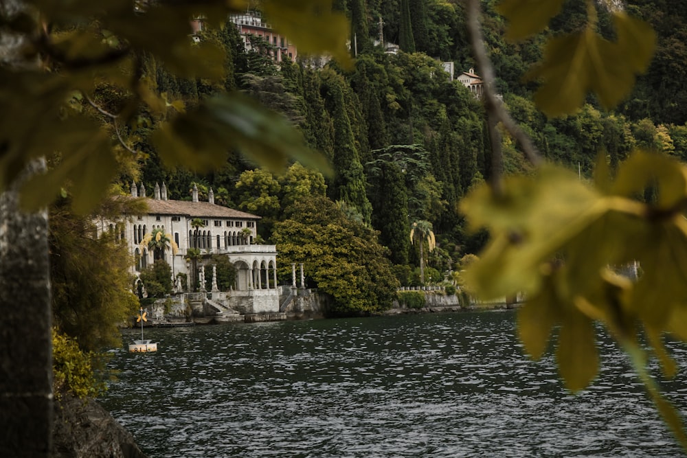 Une grande maison blanche assise au sommet d’une colline verdoyante