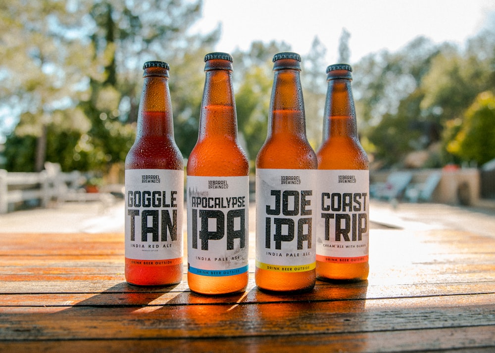 four assorted beer bottles on table