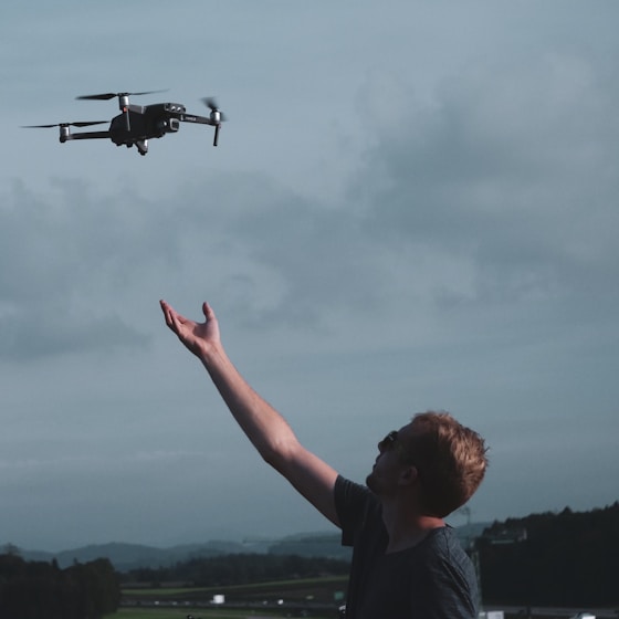man wearing black t-shirt under black quadcopter