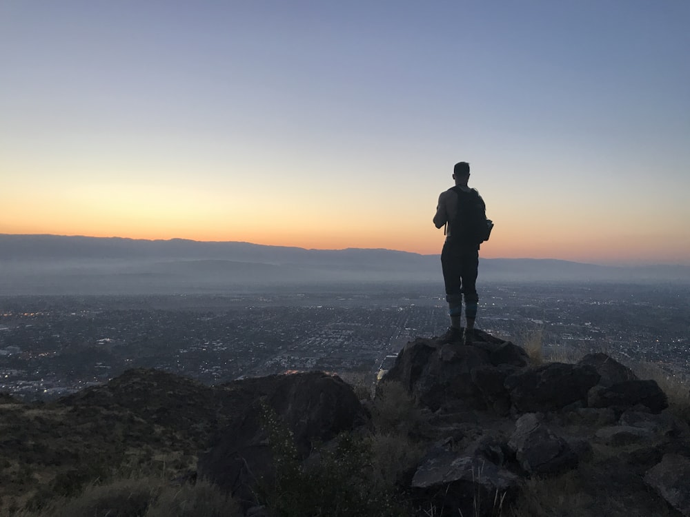 person standing on gray rock