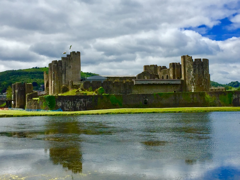 Antico castello di fronte allo specchio d'acqua sotto il cielo nuvoloso