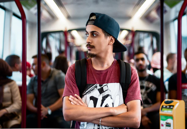 A cheerful young man using public transport confidently with a backpack.