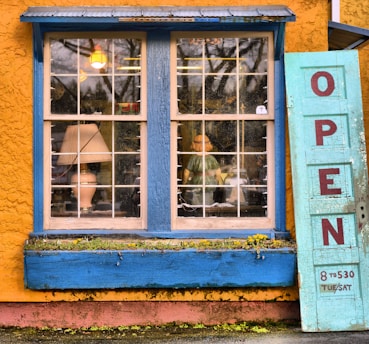blue wooden panel door placed outside a glass window