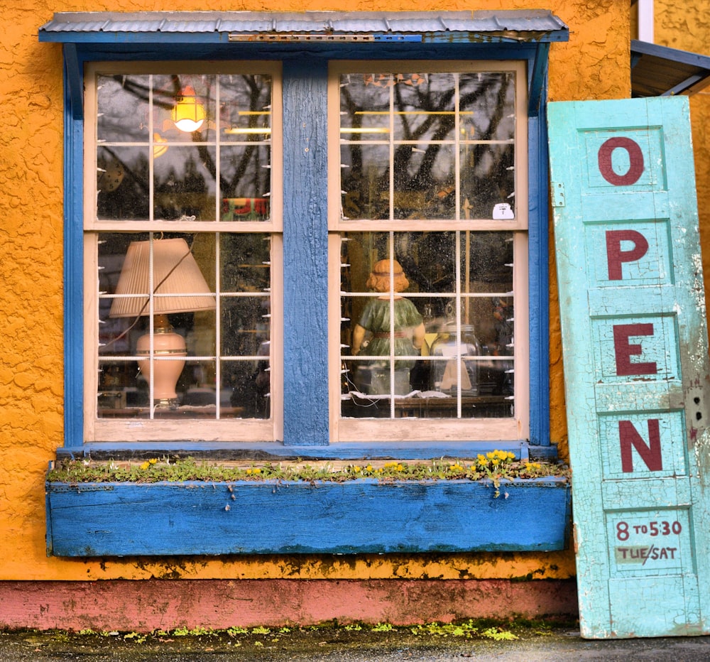 blue wooden panel door placed outside a glass window