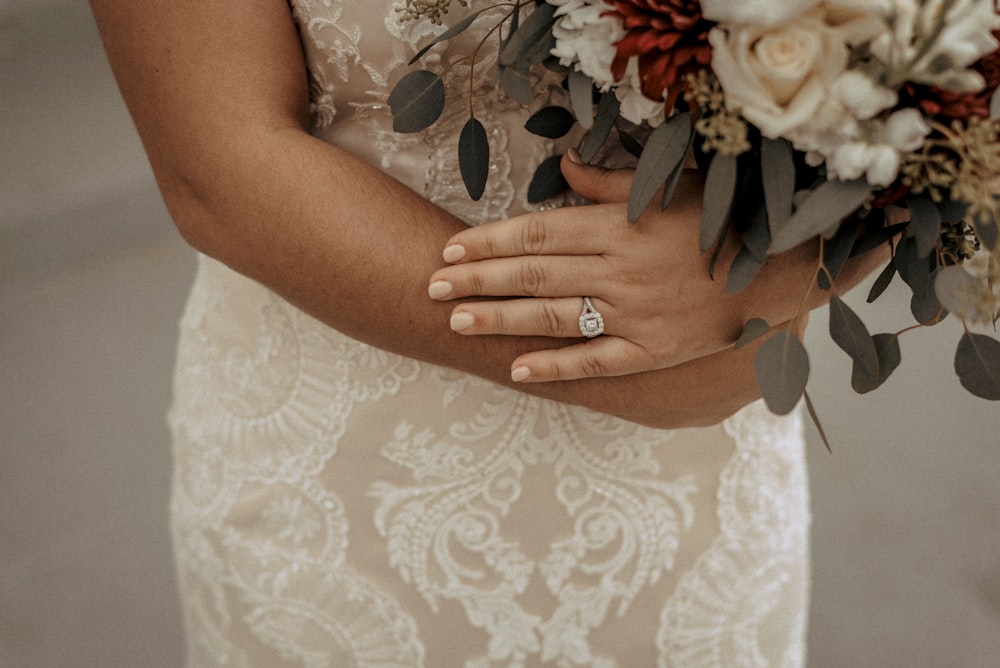 a close up of a person holding a bouquet of flowers