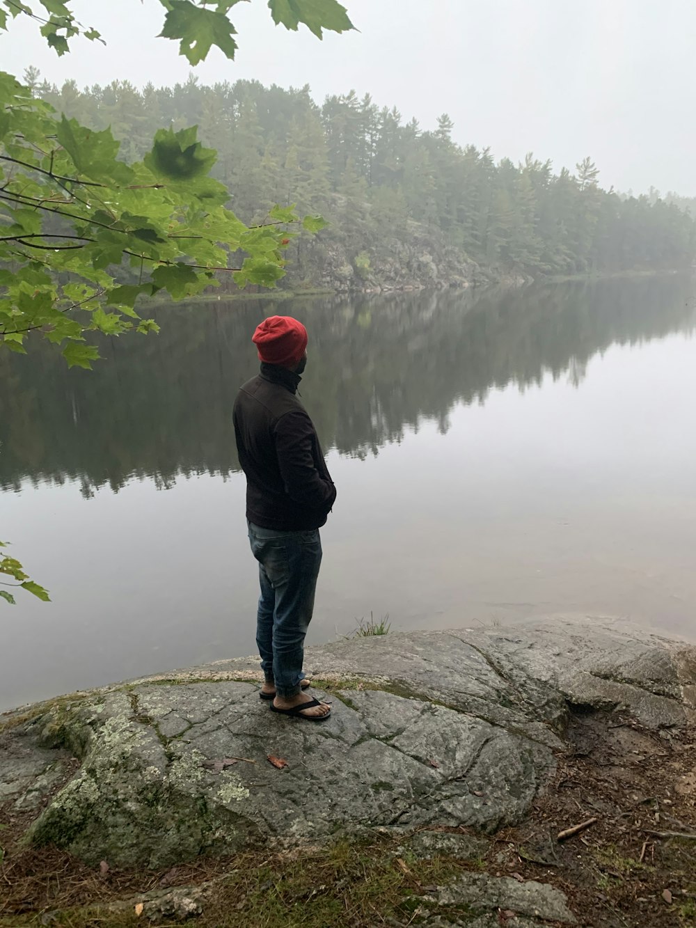 man standing beside lake