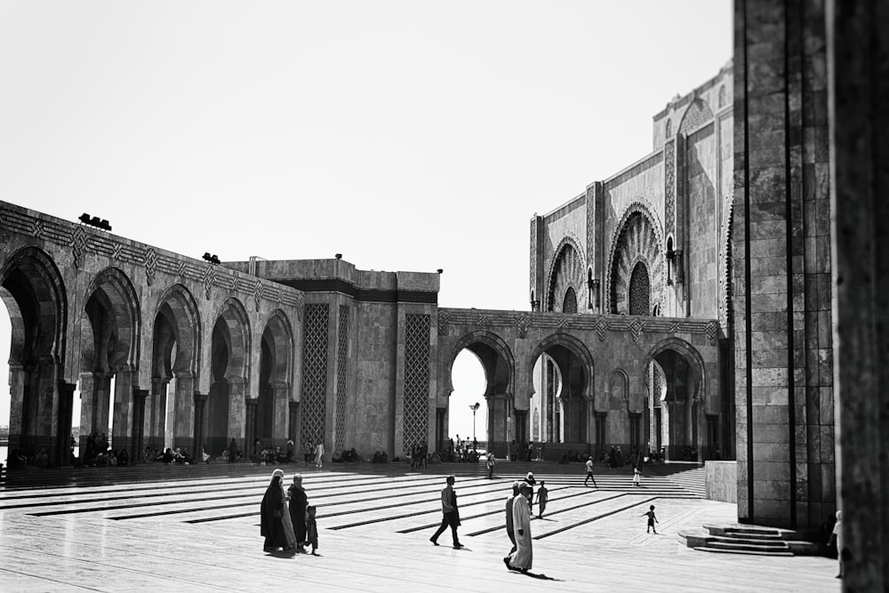 grayscale photography of people walking near building