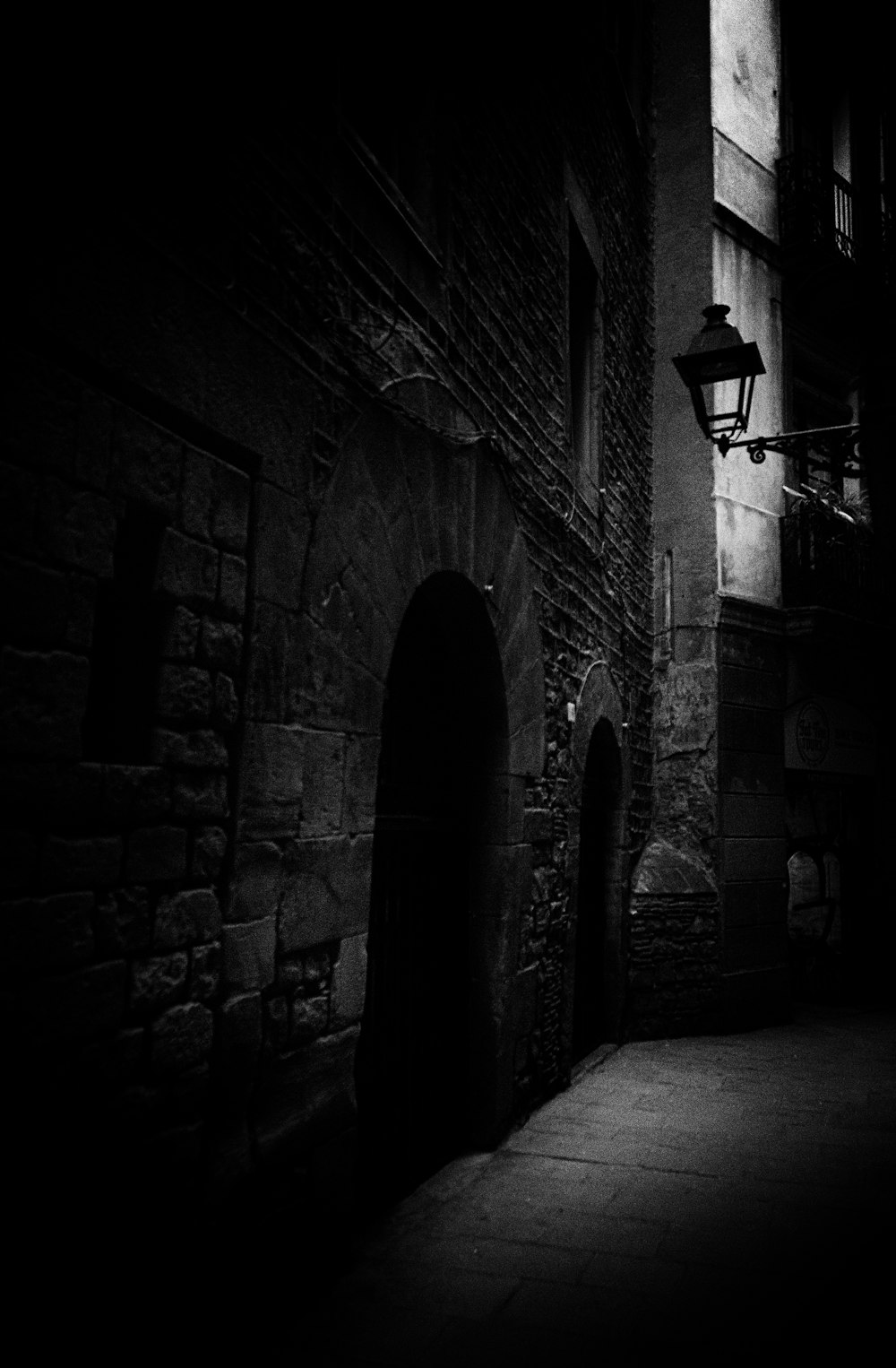 a black and white photo of a dark alleyway