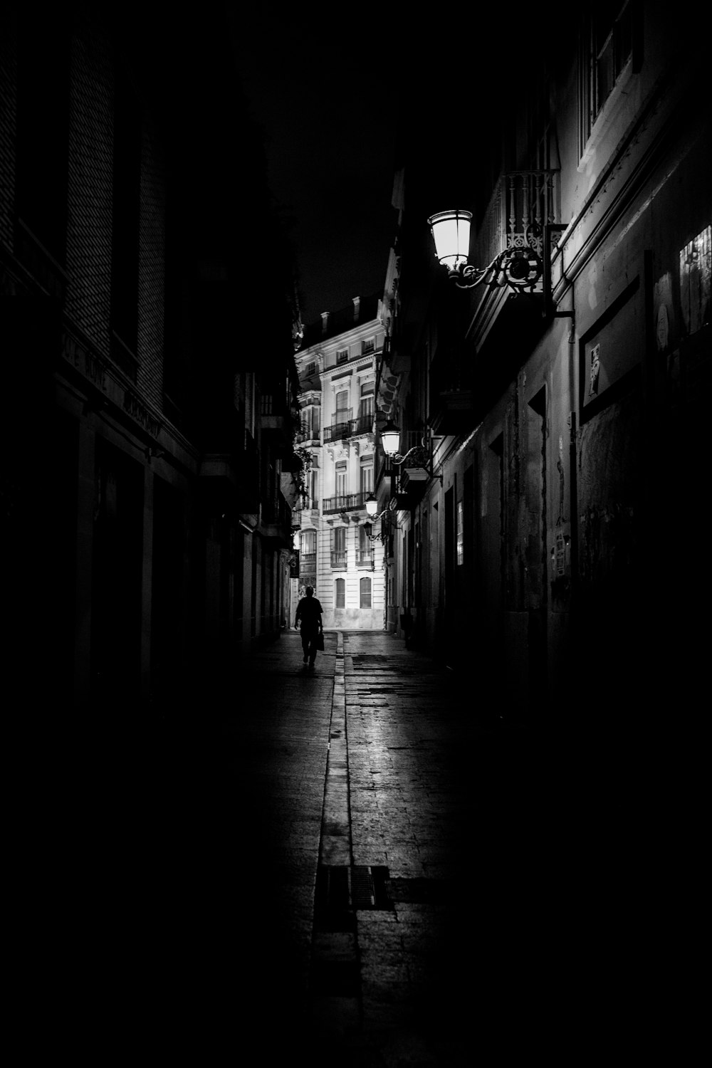 a person walking down a dark street at night