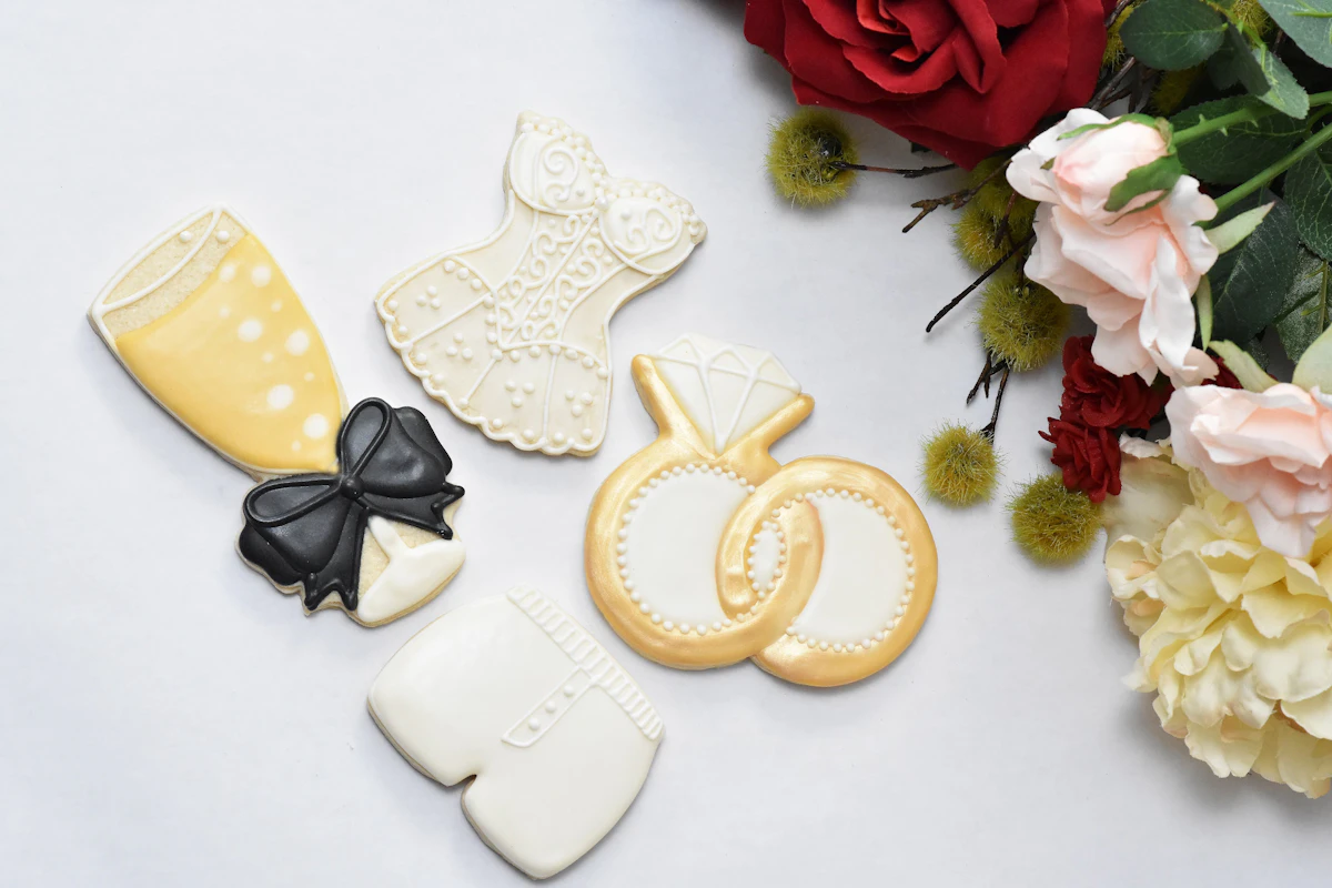 Decorated cookies and flowers on a white surface