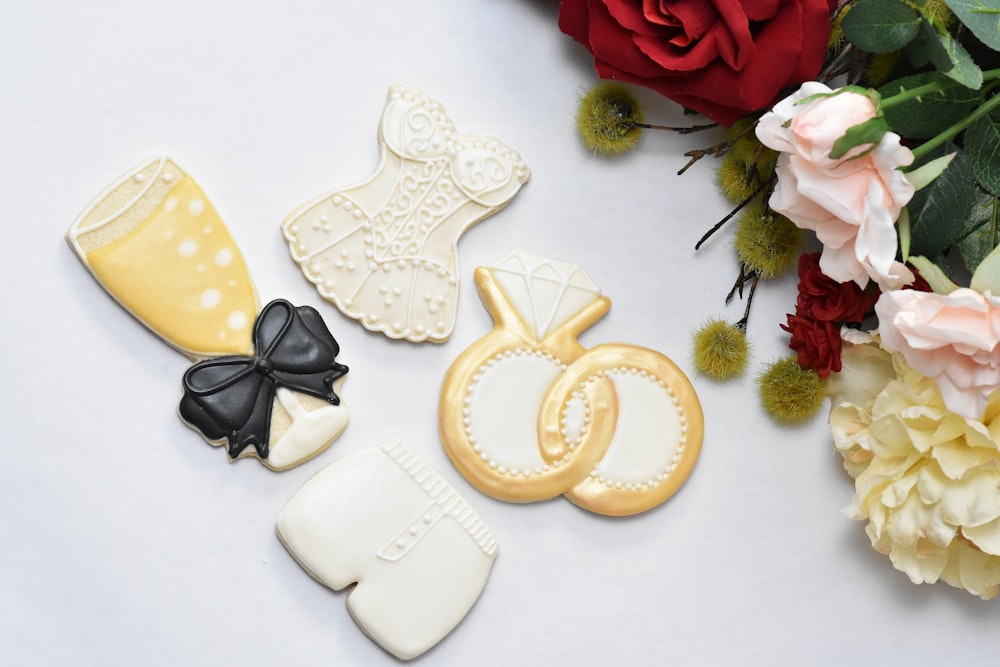 decorated cookies and flowers on a white surface