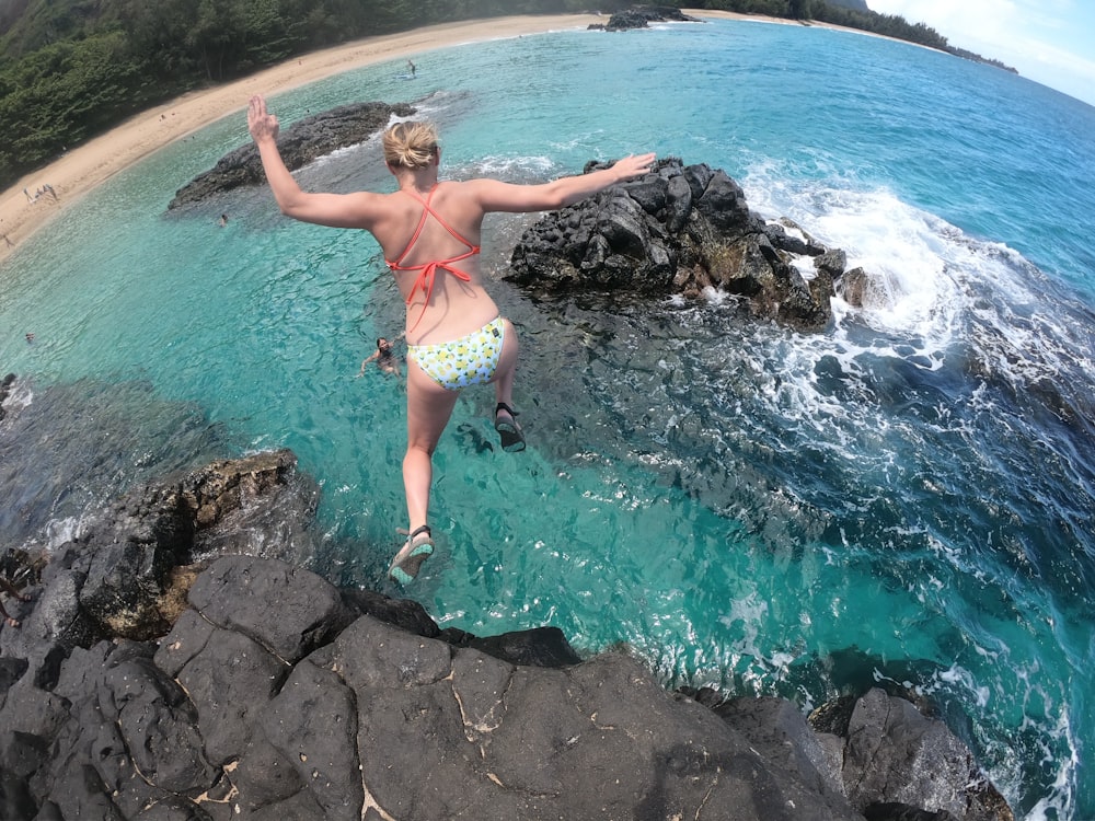 woman jumping on body of water in high-angle photo