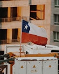 selective focus photography of raised flag on white and yellow machine during daytime