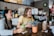 A group of mature friends laughing and sharing stories over coffee at a cozy café.