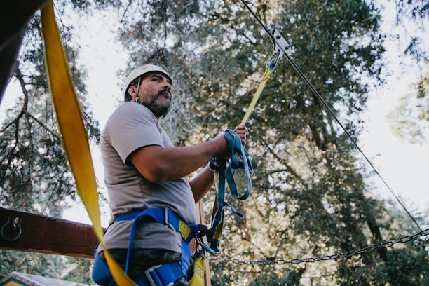 A professional engineer inspecting a forested construction site with safety gear.