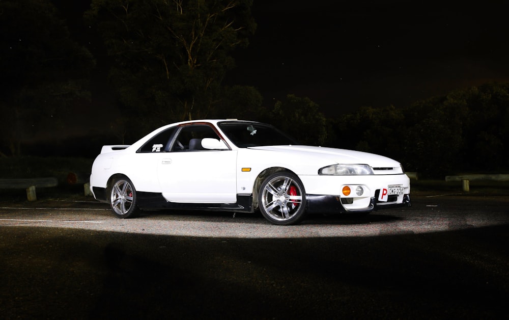 parked white coupe beside curb