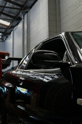 Close-up of a glossy black epoxy floor reflecting ambient lighting in a modern garage.