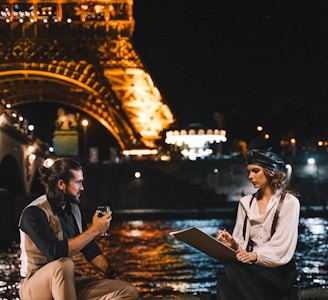 man and woman sitting near Eiffel Tower Paris France