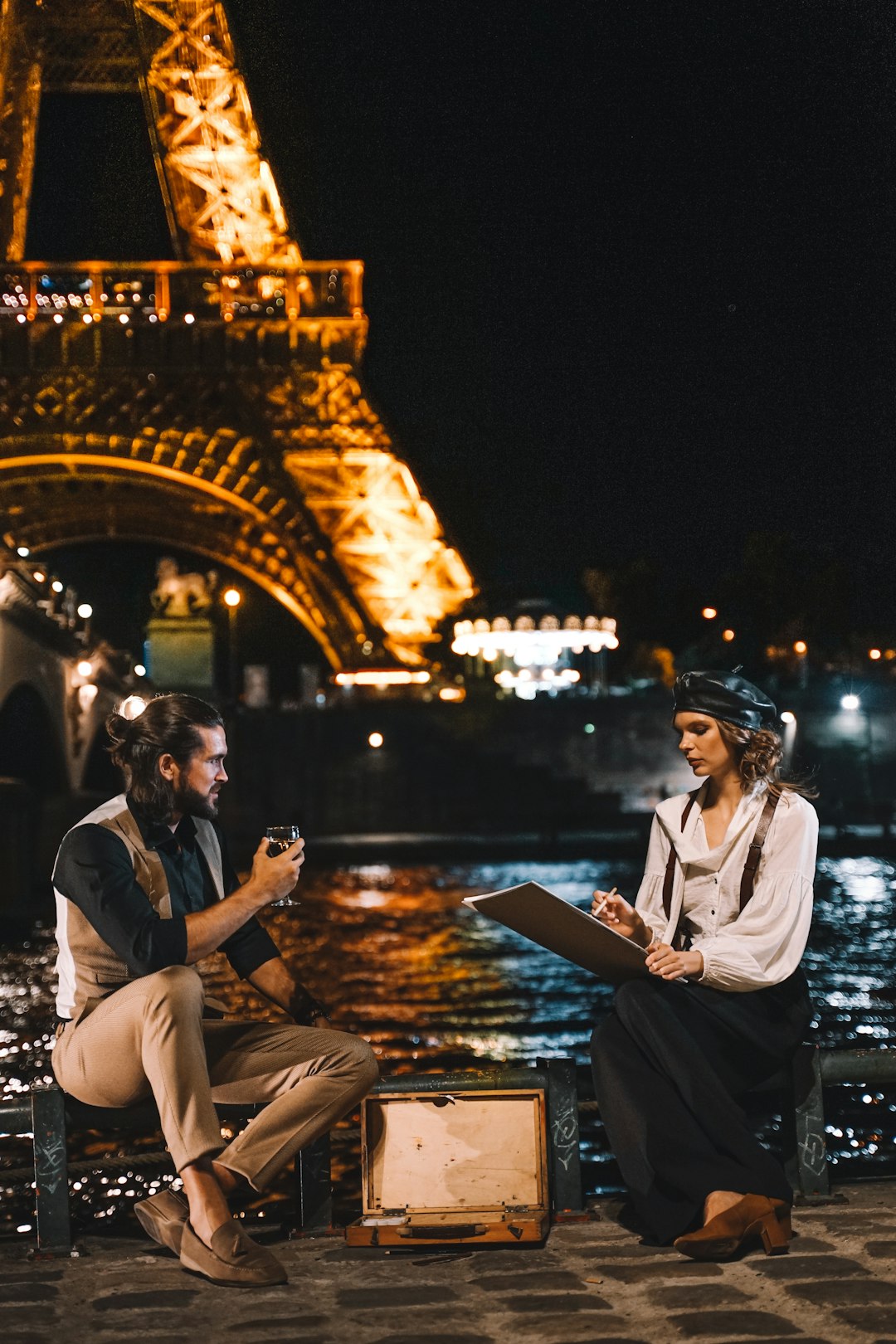 man and woman sitting near Eiffel Tower Paris France
