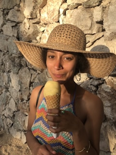 A happy customer wearing a colorful crocheted hat outdoors on a sunny day.