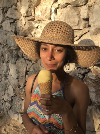 A happy customer wearing a colorful crocheted hat outdoors on a sunny day.