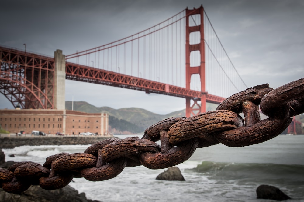 Un primer plano de una cadena con un puente en el fondo