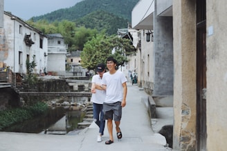 A happy elderly couple enjoying a peaceful walk along a quiet Romanian village street.