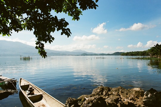 gray boat on sea beside rock formation in Buhi Philippines