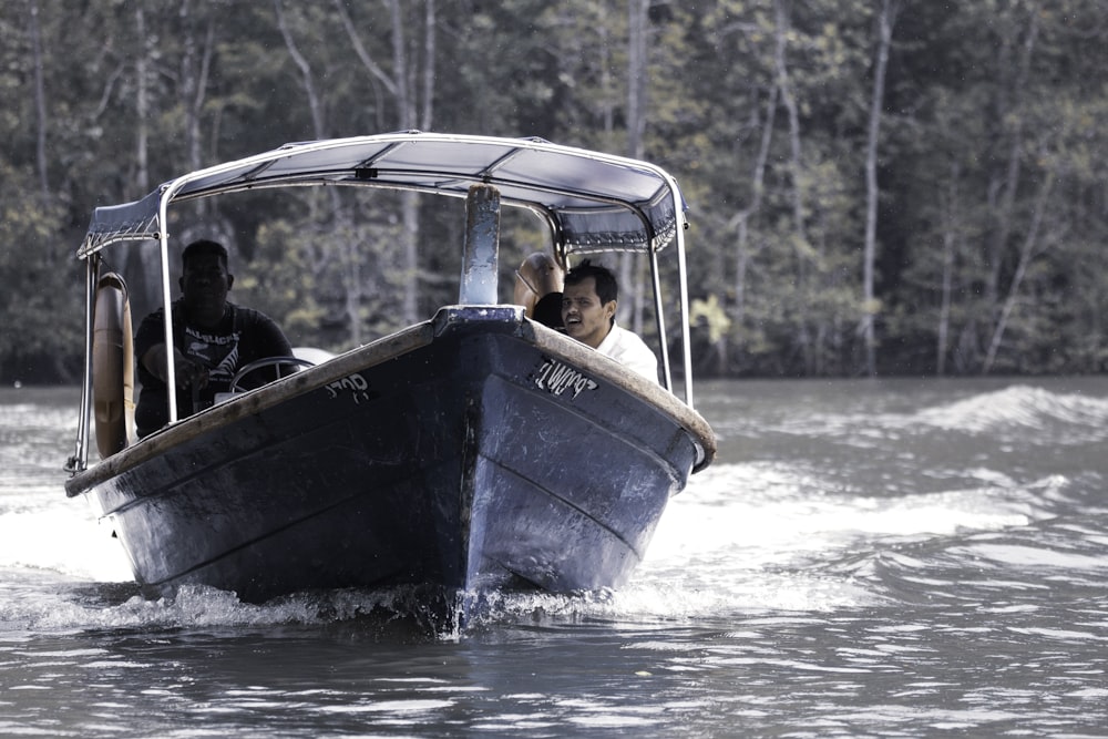 Männer fahren tagsüber auf einem grauen Boot