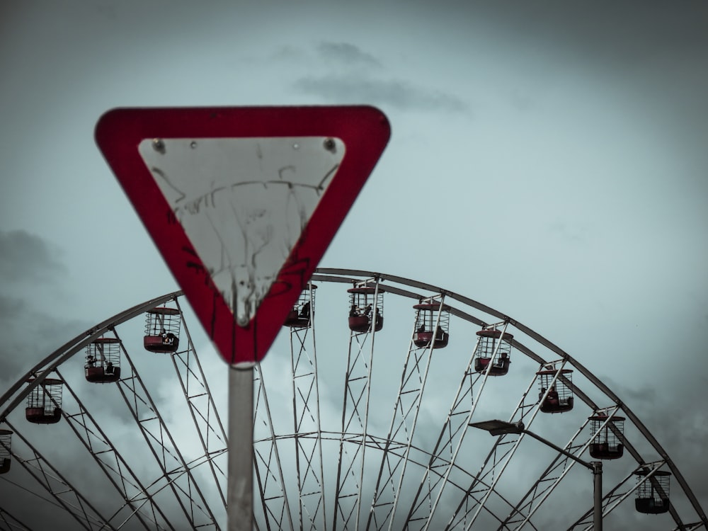 red and white road sign near Ferris Wheel